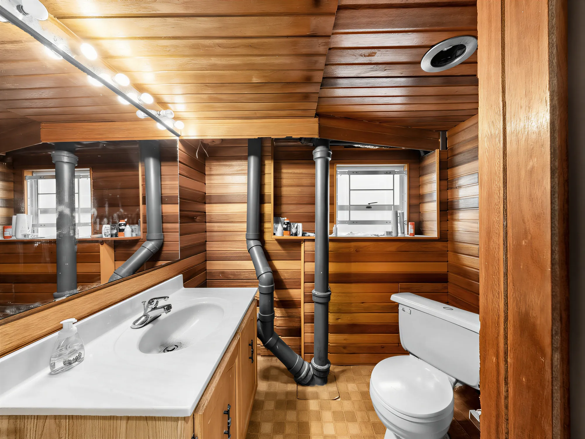 A cedar-lined bathroom with the house plumbing stacks running through it