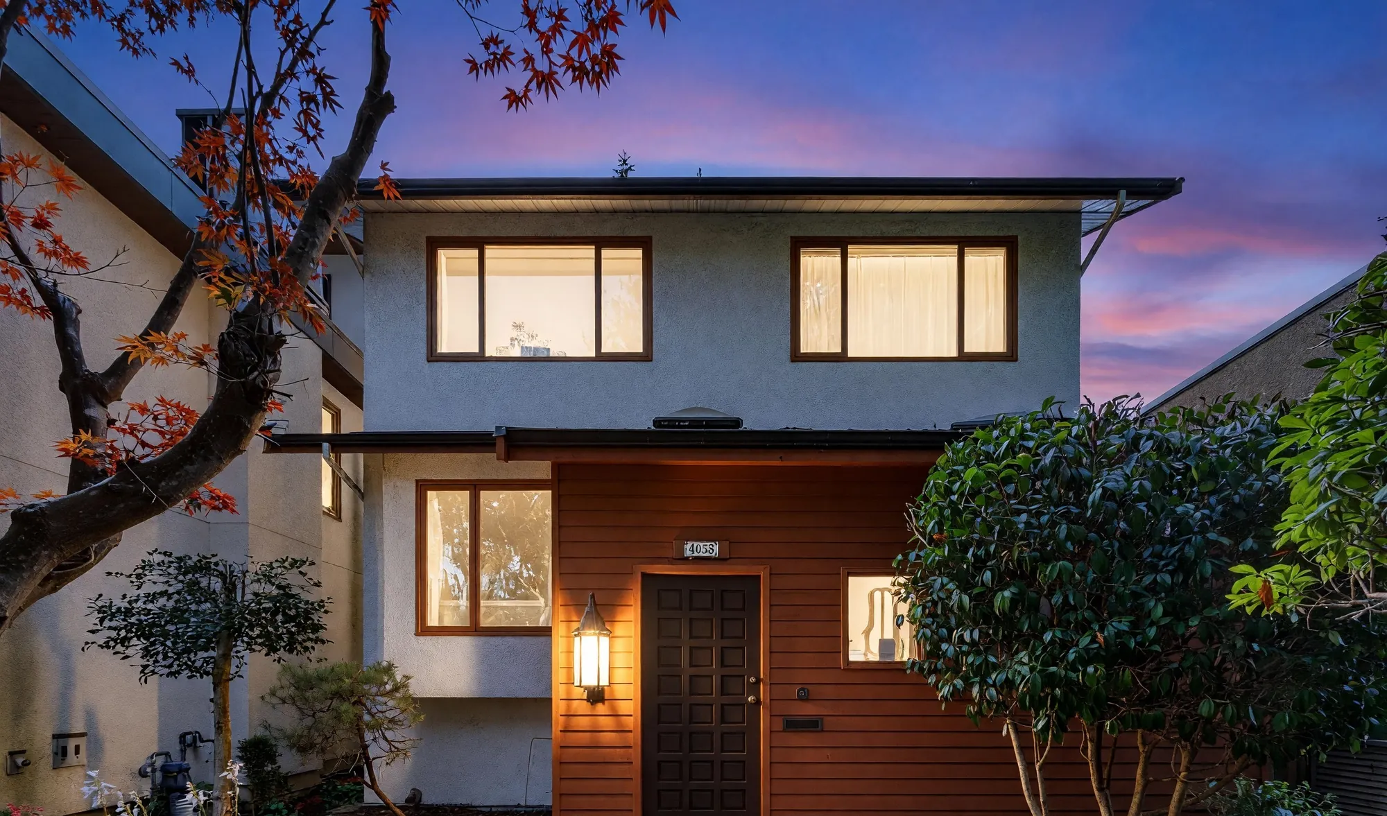 The front of 4058 West 17th Avenue at dusk, with a Japanese maple beside the entry