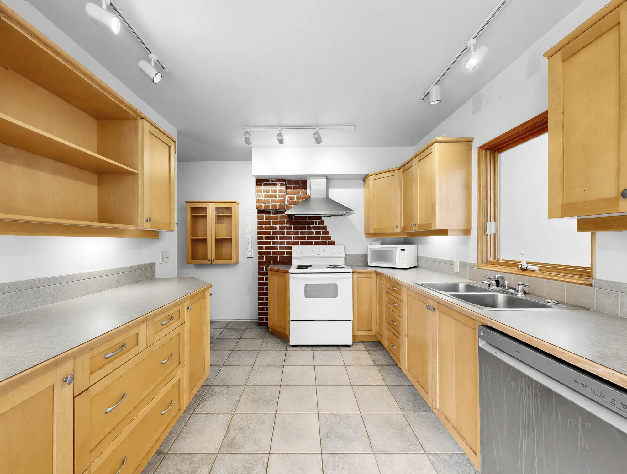 The range wall of the kitchen with brick behind and open shelving alongside