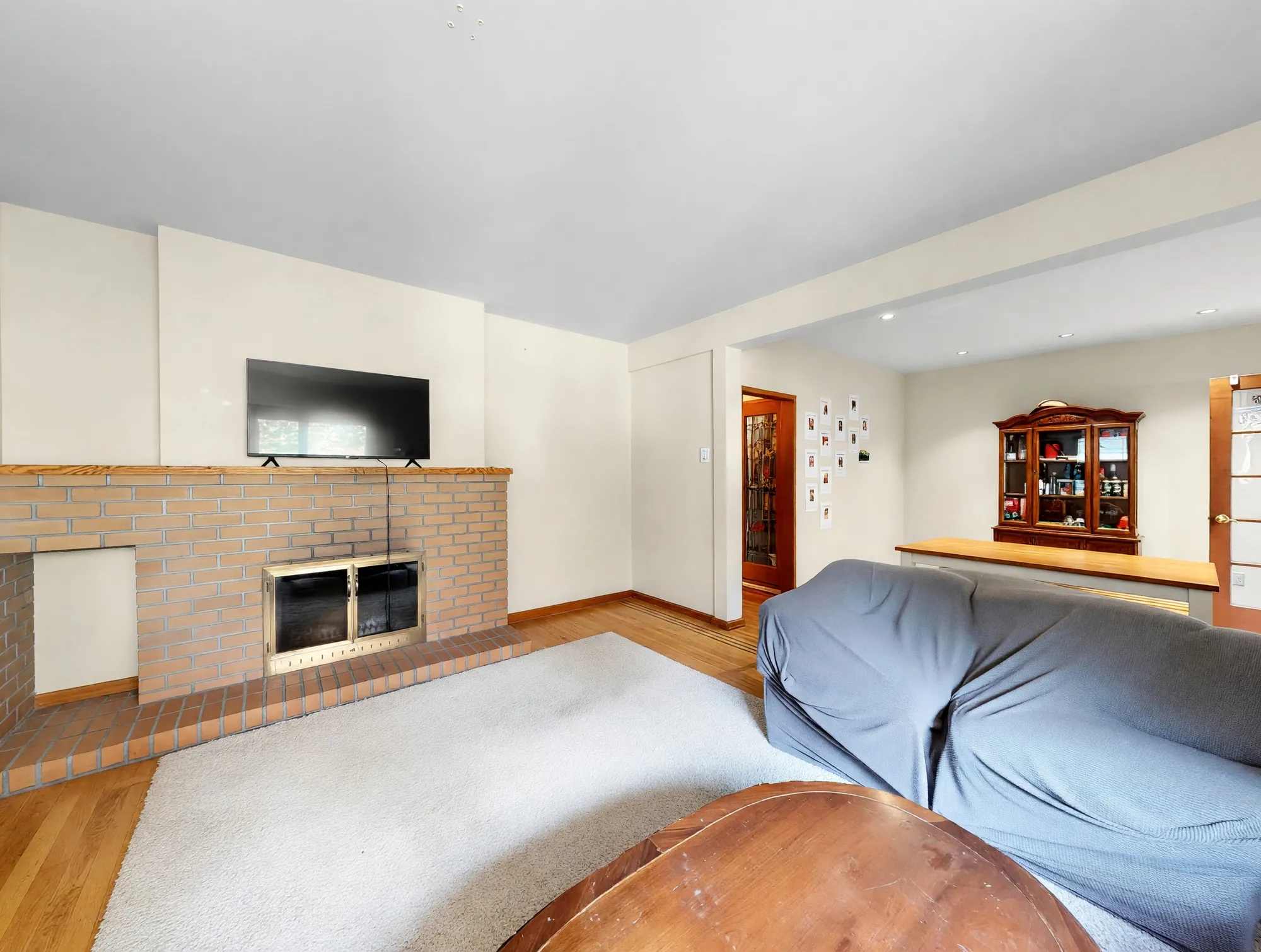 The brick fireplace wall and the opening through to the dining room