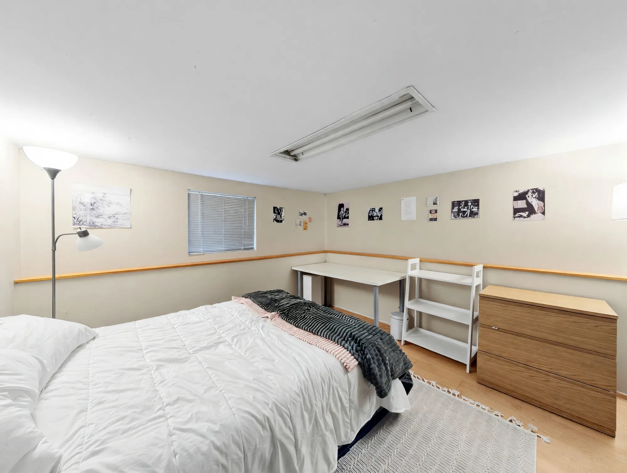 A long low room with a knee wall along one side and hardwood floor