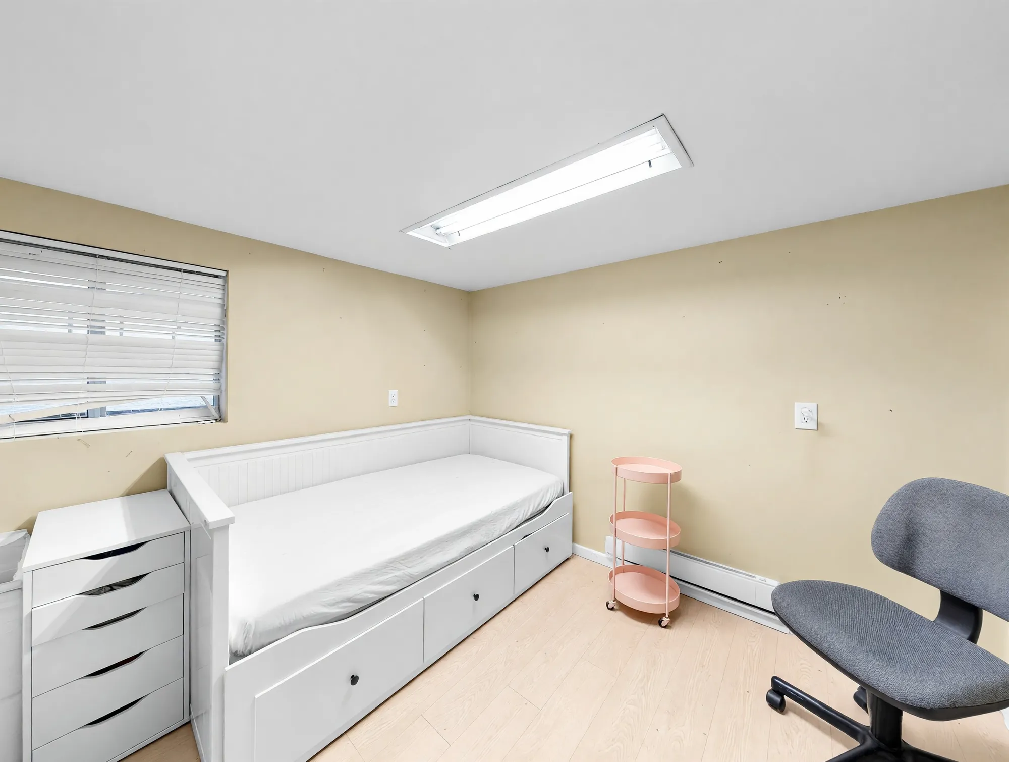 A room in use as a study, with a daybed against the wall and a desk chair