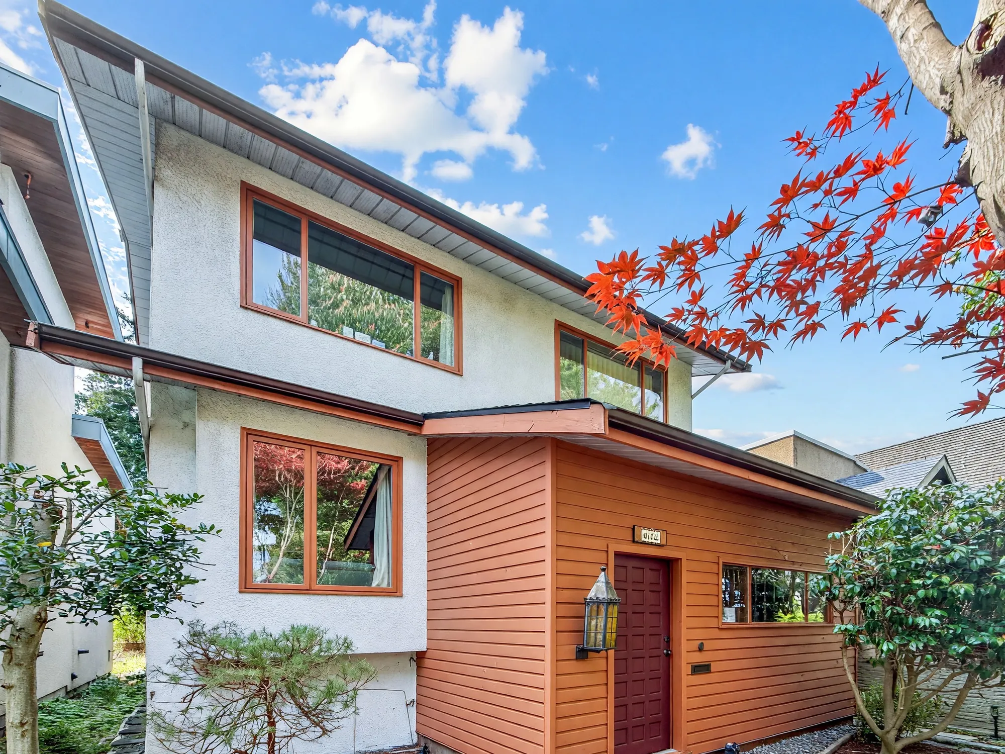 Looking along the side of the house toward the wood-clad entry